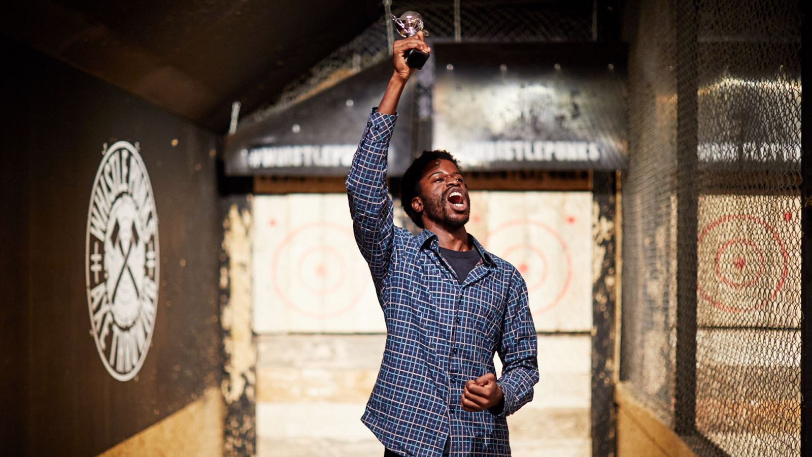 Man holding trophy in the air at Whistle Punks axe throwing Bristol